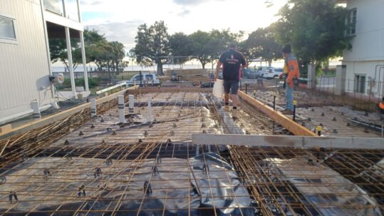 Trades people working with steel reinforcements for concrete slab